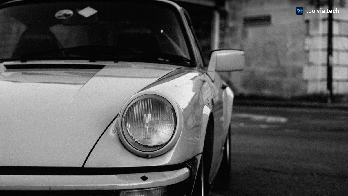 Black and white photo of a classic Porsche 911 headlight and front bumper