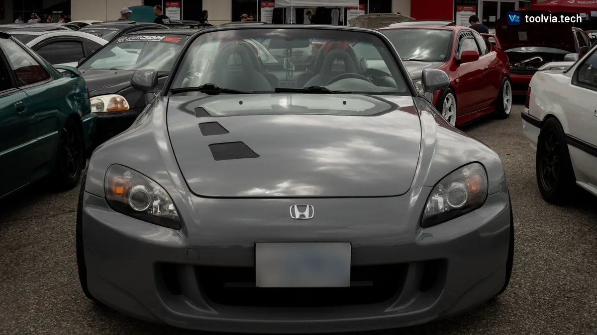 Grey Honda S2000 roadster parked in front of a Honda dealership