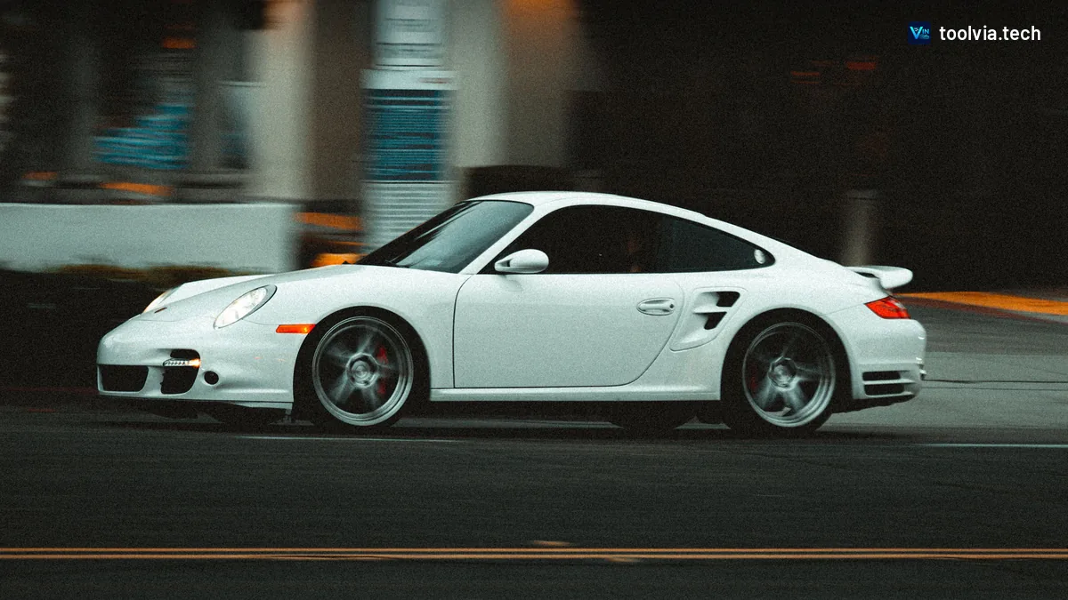 White Porsche 911 Turbo driving past, side view with motion blur